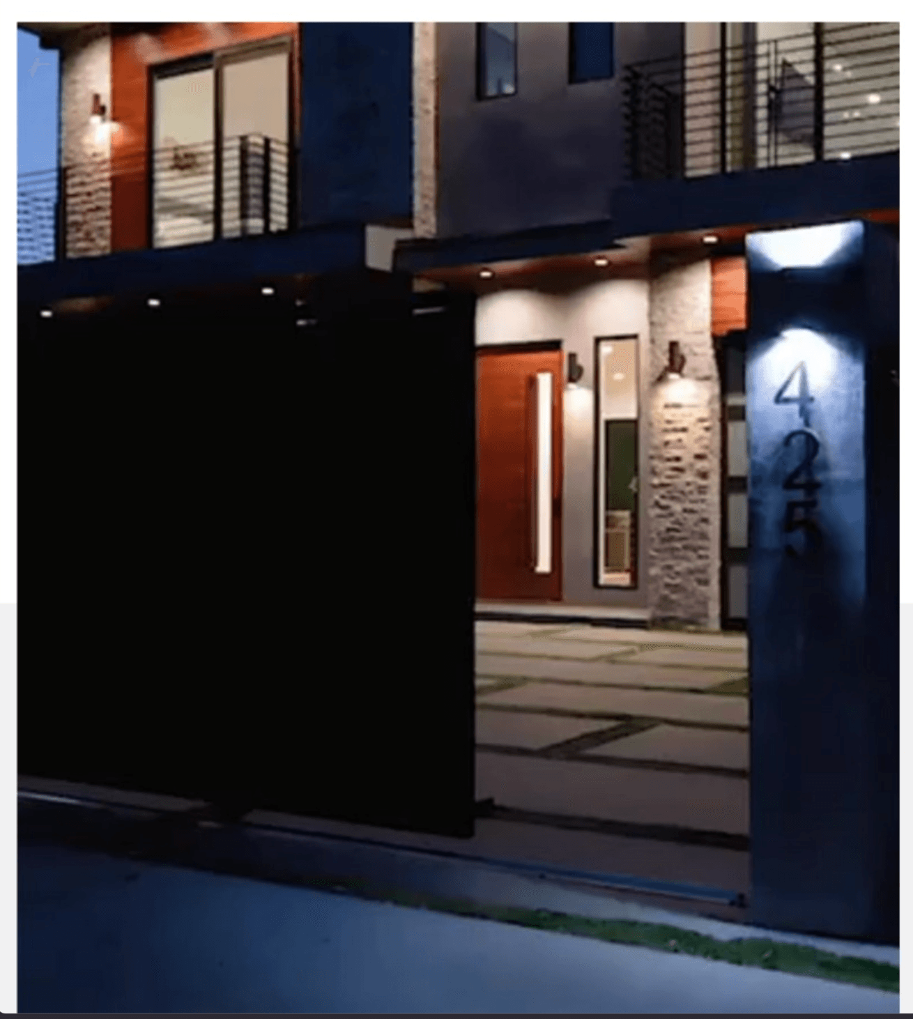 Contemporary residential façade at dusk with warm exterior lighting